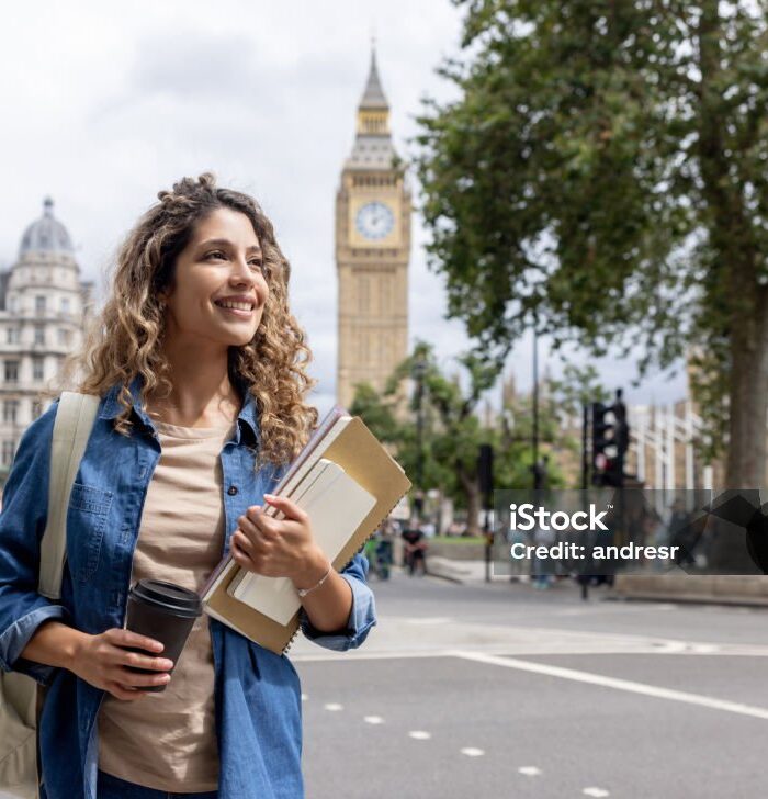 istockphoto-1597407164-1024x1024 Portrait of a happy exchange student walking outdoors in London and drinking coffee on-the-go